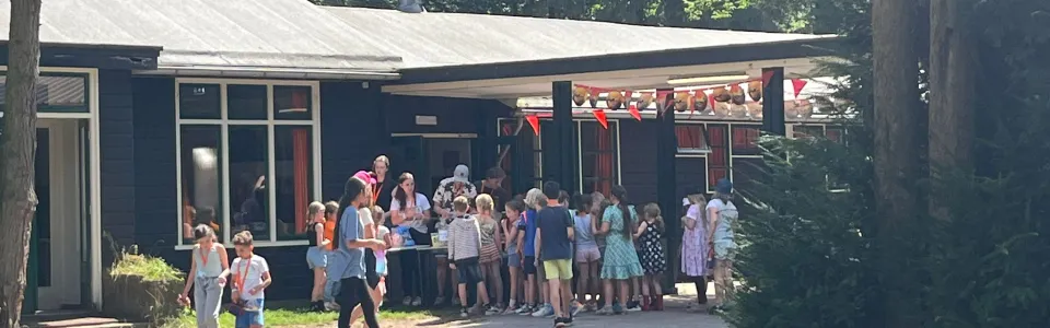 Deelnemers verzamelen zich voor het kampgebouw