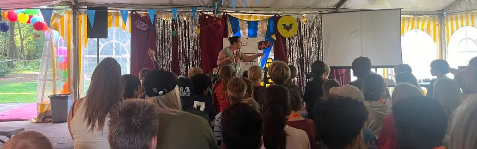 Deelnemers kijken naar het programma in de zaal