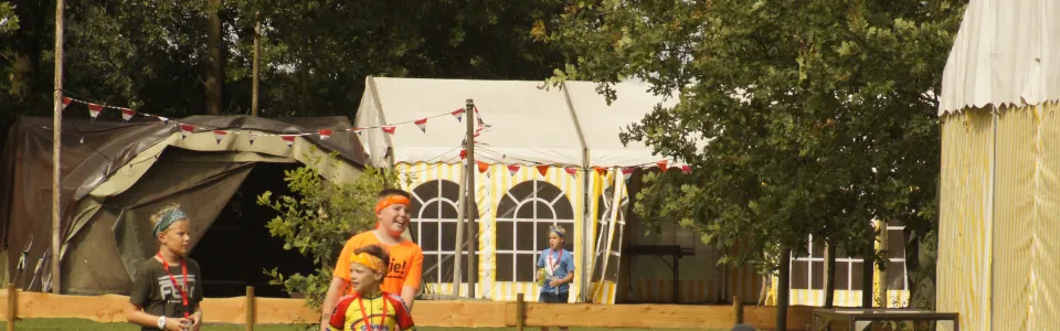 Deelnemers spelen een balspel voor de tent