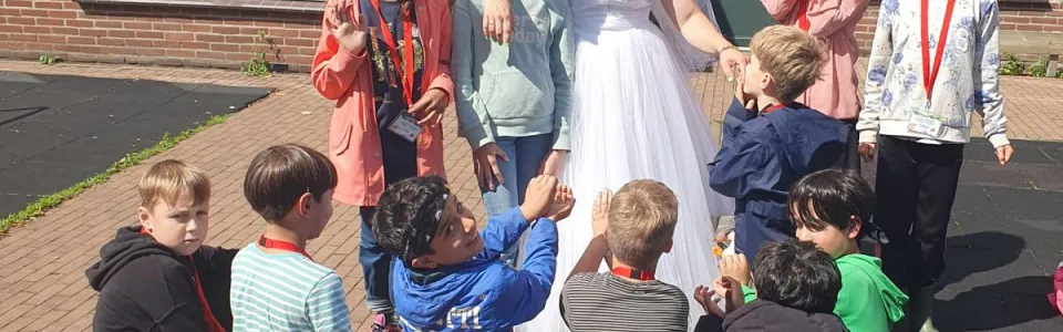 Deelnemers zitten in een kring op het plein bij het gebouw