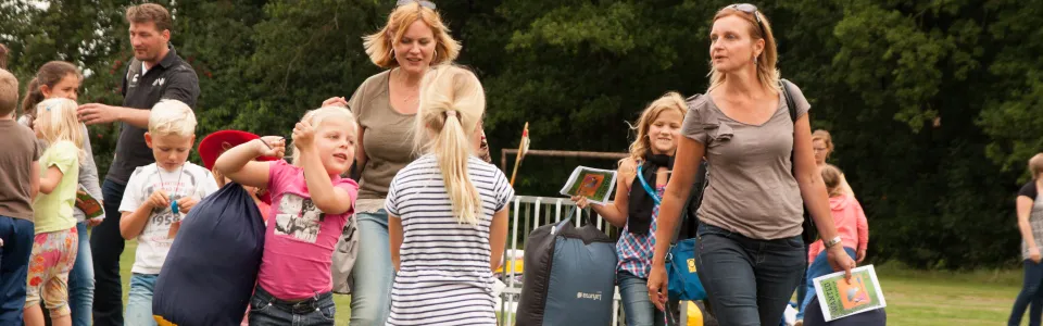Ouders en kinderen nemen afscheid bij het kampgebouw