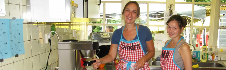 Twee keukenmedewerkers aan het werk in de kampkeuken