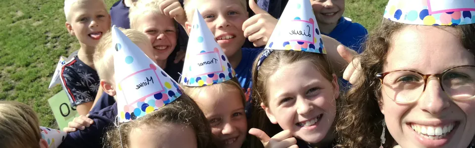Deelnemers met feestmutsen op de eerste kampdag