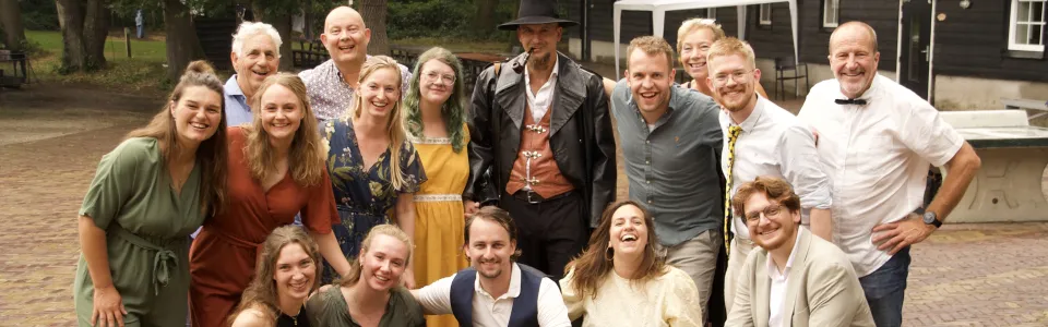 Lachend leidingteam poseert samen op het groene kampterrein