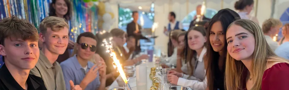 Deelnemers aan een feestelijk gedekte tafel