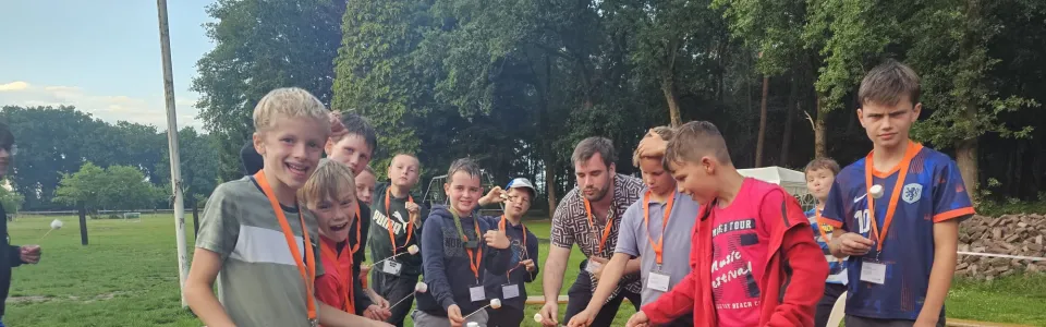 Deelnemers rond een vuurkorf