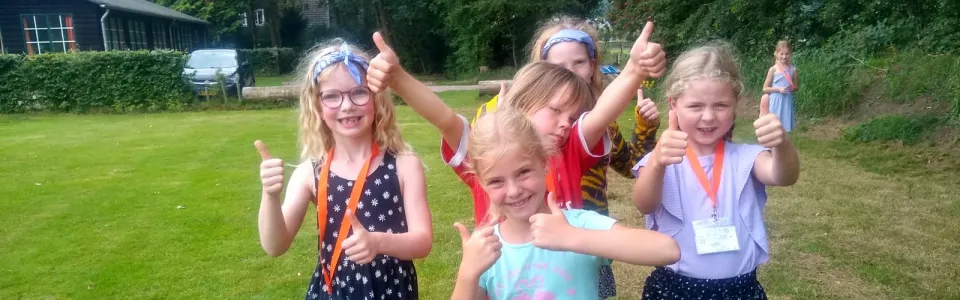 Deelnemers poseren op het grasveld