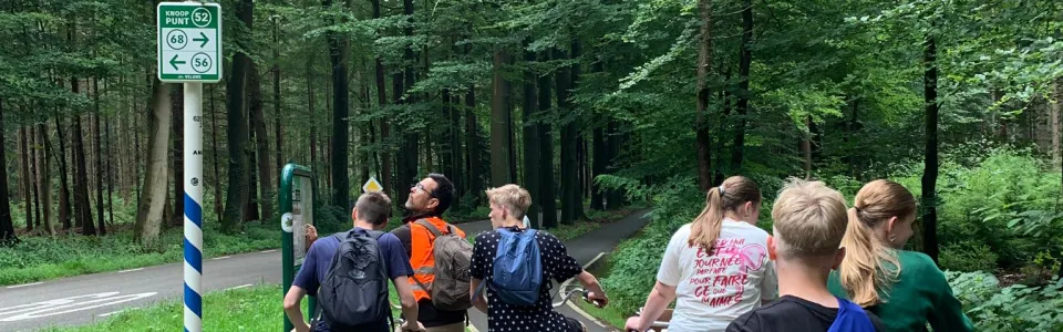 Tieners fietsen samen door het groene bos tijdens tienerkamp1