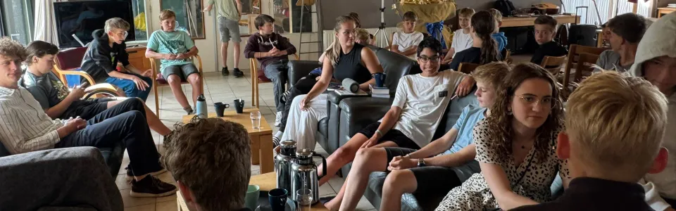 Deelnemers kijken naar het programma in de zaal