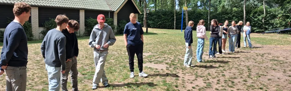 Deelnemers spelen een spel op het zandveld