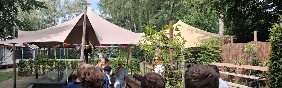 Deelnemers onder een parasol bij het terras