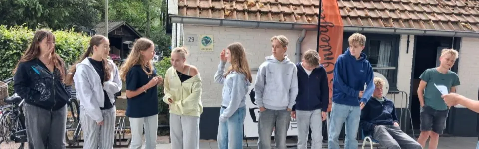 Deelnemers staan te praten bij het kampgebouw