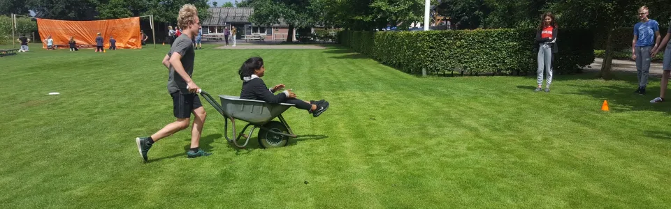 Deelnemer rijdt met een bolderkar over het grasveld