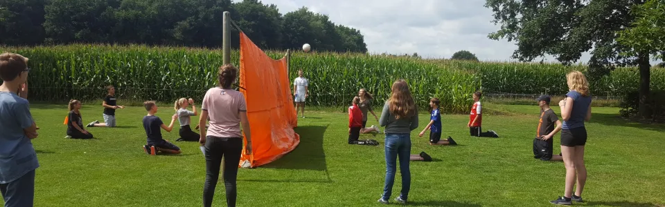 Buitenspellen op een grasveld met een oranje vlag