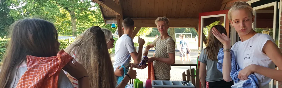 Deelnemers aan tafel onder een overkapping