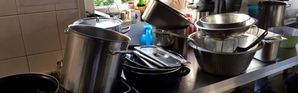 Stapels pannen in de kampkeuken