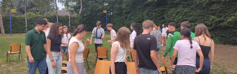 Deelnemers spelen een stoelendans op het grasveld