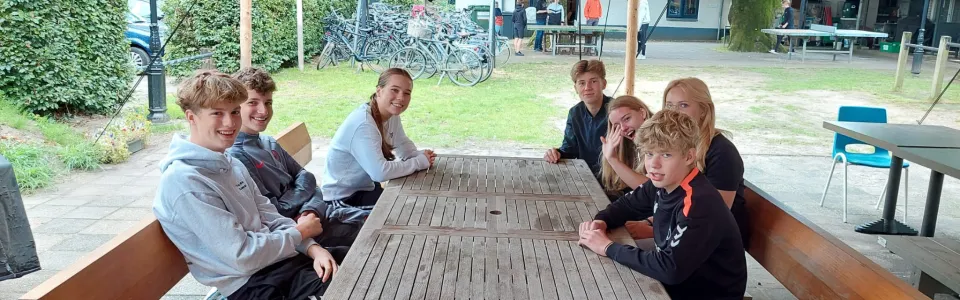 Deelnemers aan picknicktafels onder een luifel
