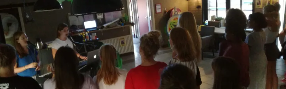 Deelnemers in de zaal met groene versiering
