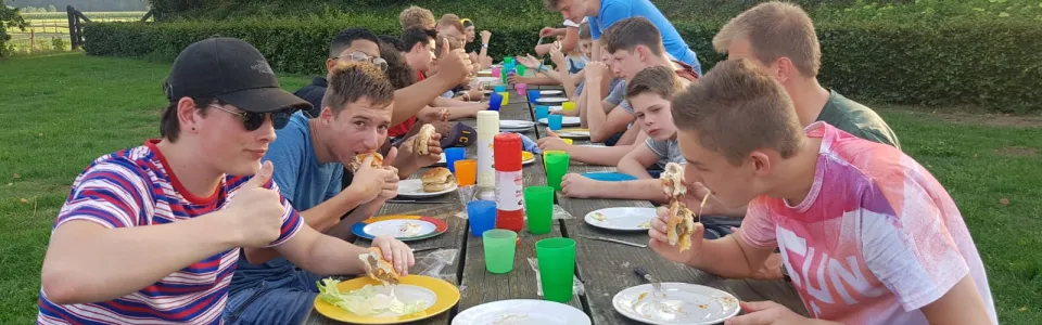 Deelnemers eten samen aan een lange tafel