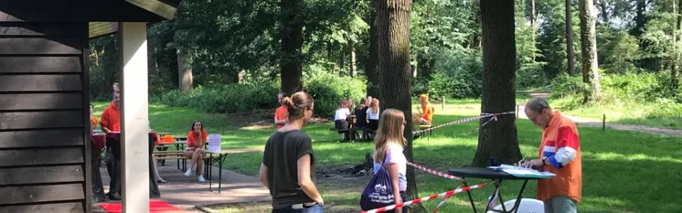 Deelnemers bij het kampgebouw met een rode loper