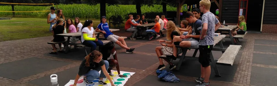 Deelnemers spelen tafeltennis en tafelvoetbal buiten