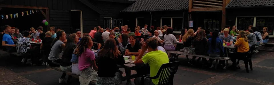 Deelnemers aan tafels op het terras in de avond