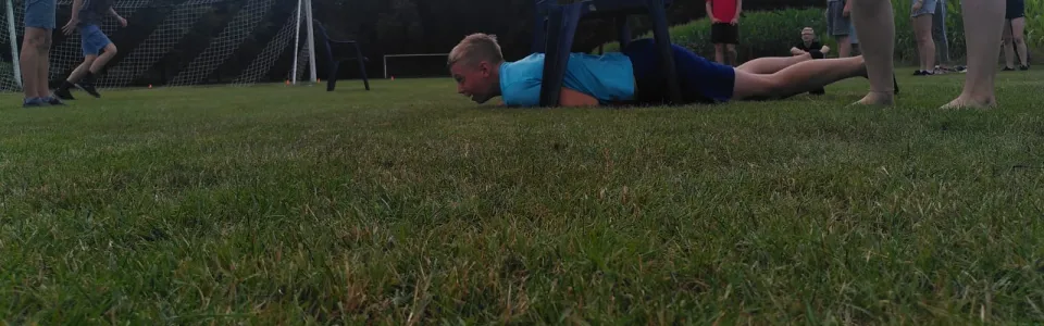 Deelnemers liggen op het grasveld tijdens een spel