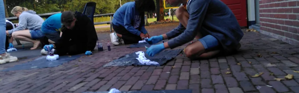 Deelnemers spelen een spel op de grond bij het gebouw