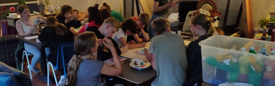 Kinderen knutselen aan tafel in de zaal