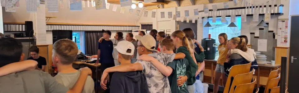 Deelnemers staan in een kring in de zaal