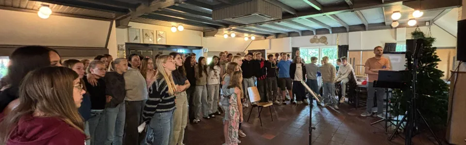 Deelnemers steken de handen omhoog tijdens het programma