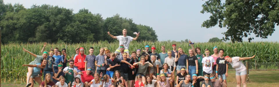 Grote groepsfoto van deelnemers voor een maisveld