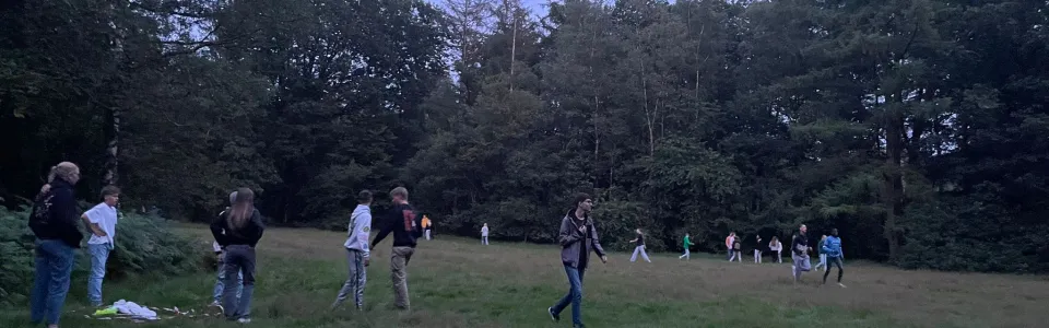 Deelnemers op het grasveld bij schemer