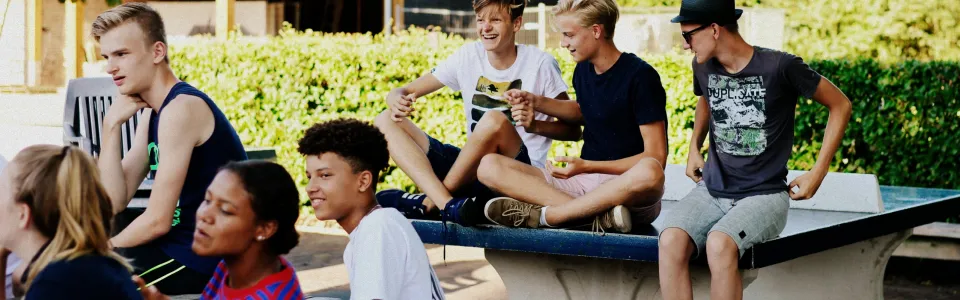 Deelnemers zitten op en rond een tafeltennistafel