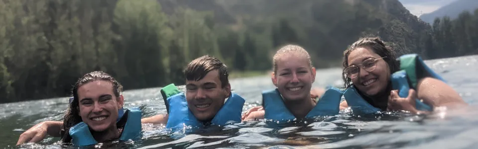 Deelnemers met zwemvest in het water van een bergmeer