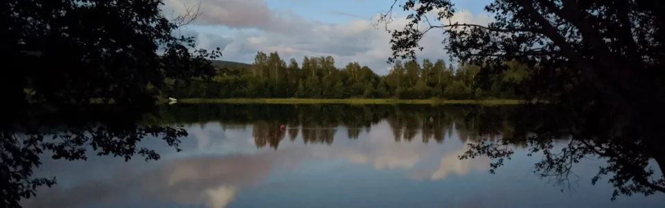 Meer met bos bij avondlicht