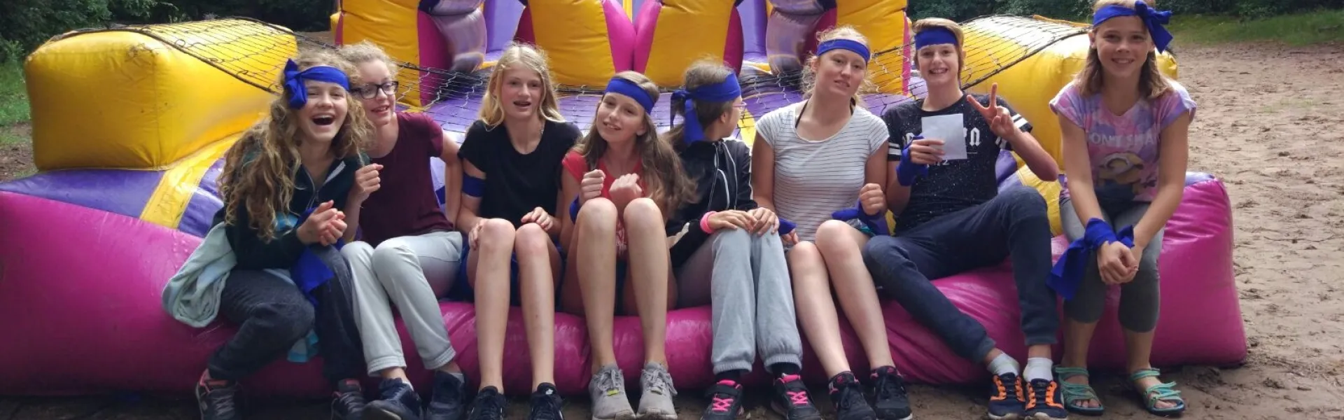 Deelnemers zitten samen op een groot springkussen