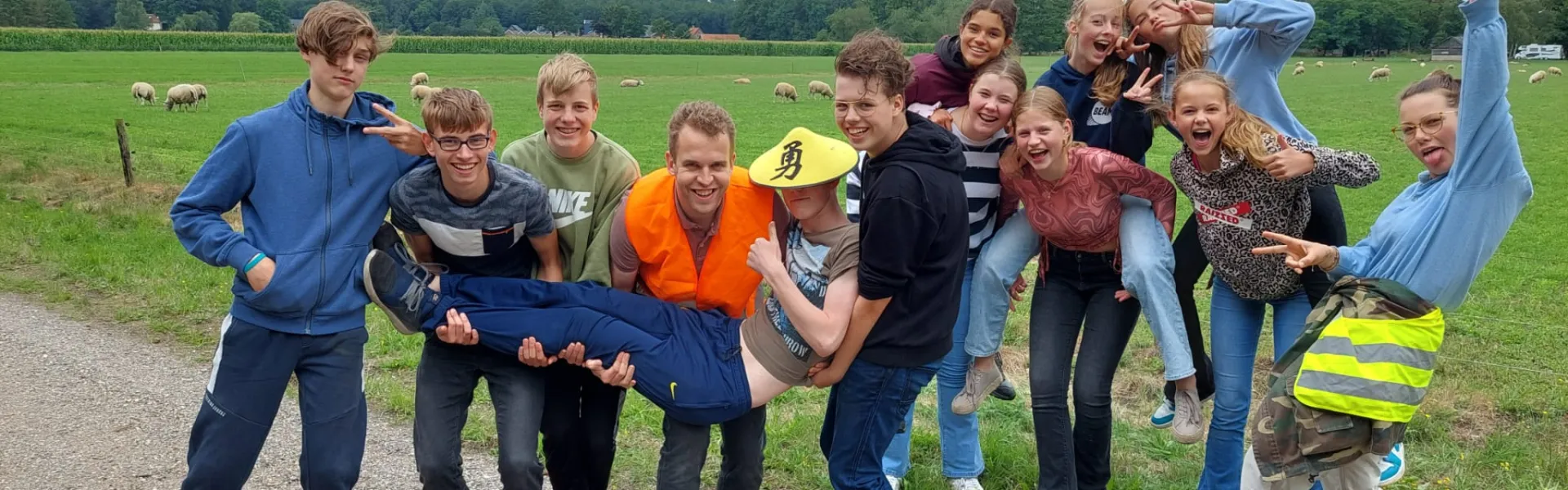 Deelnemers poseren op een pad langs het weiland