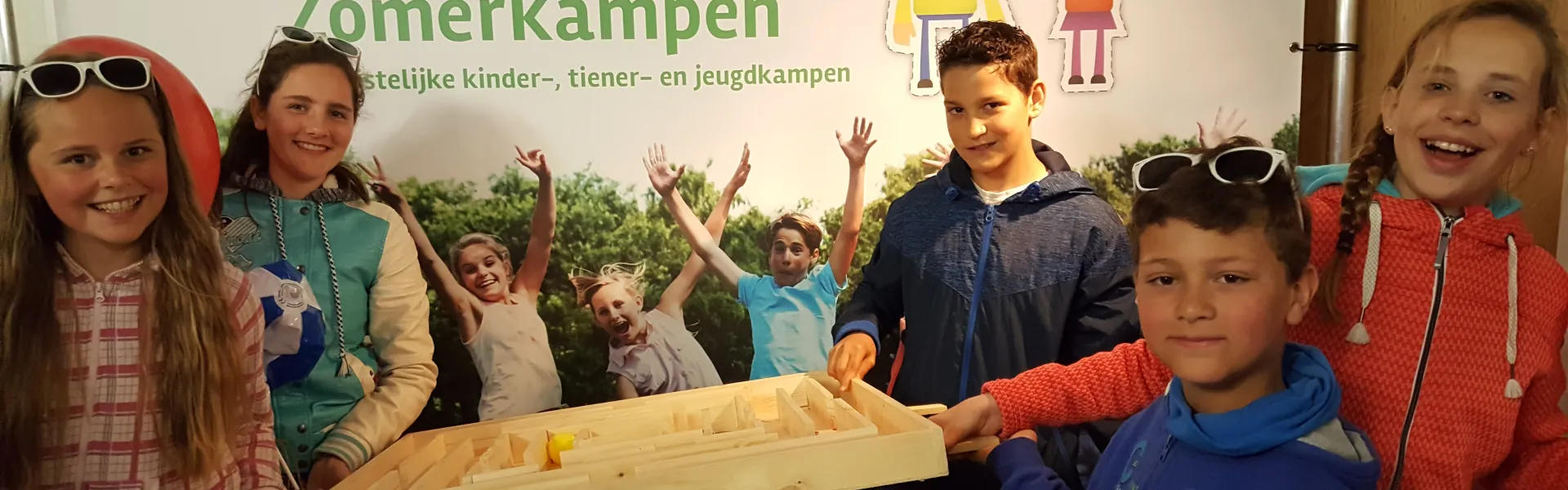 Kinderen bij de kraam van Onvergetelijke Zomerkampen op Opwekking
