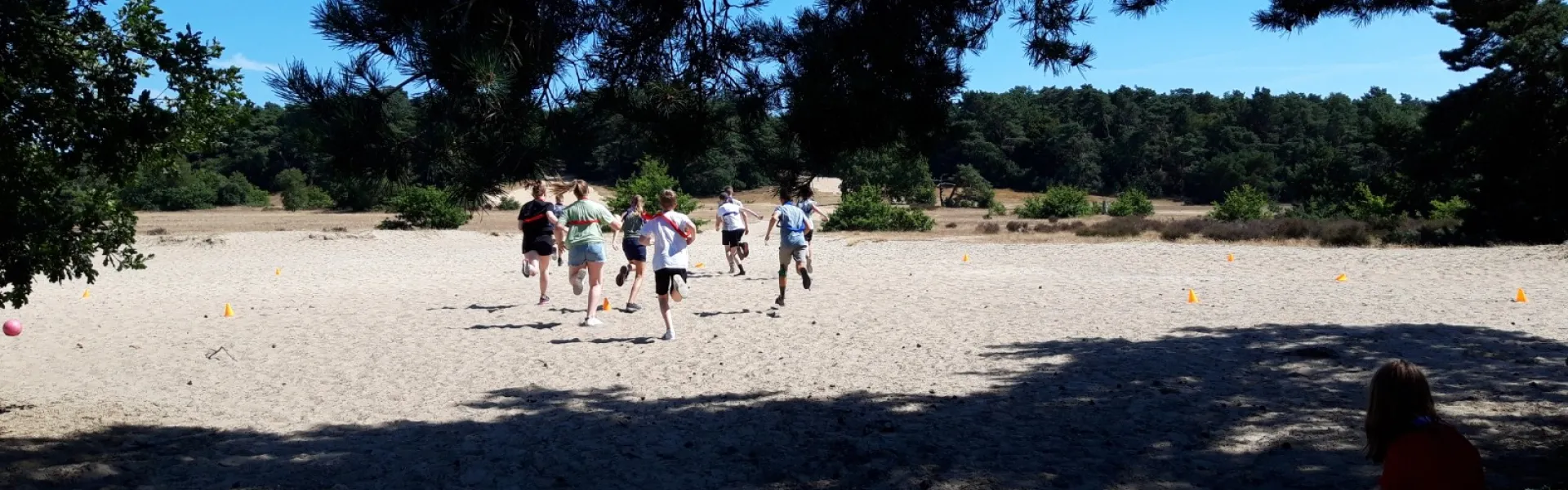 Deelnemers spelen op de zandvlakte in de zon