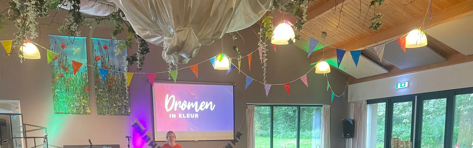 Volle zaal met deelnemers tijdens het programma Dromen in Kleur