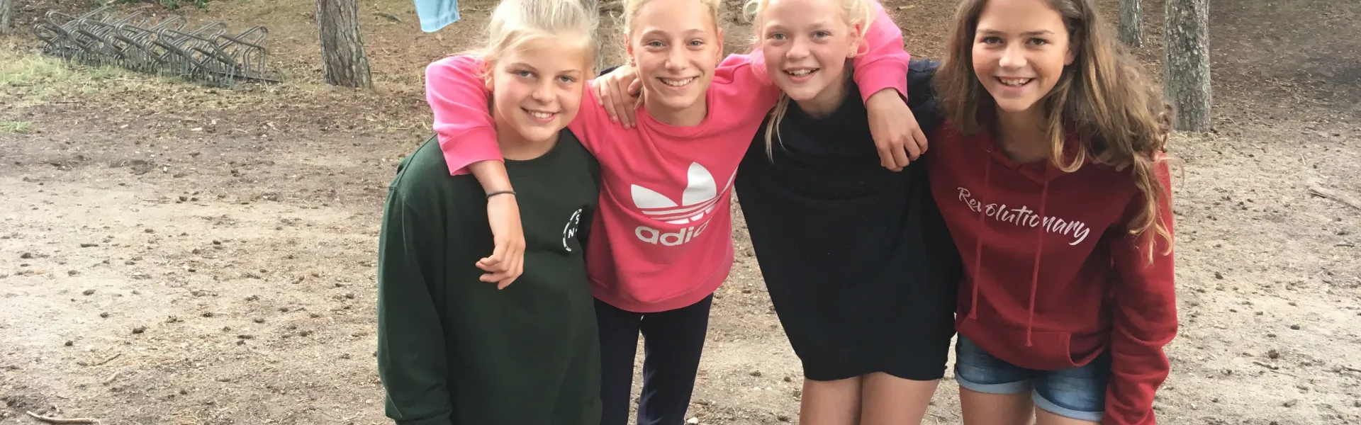 Vier meisjes poseren in het zand