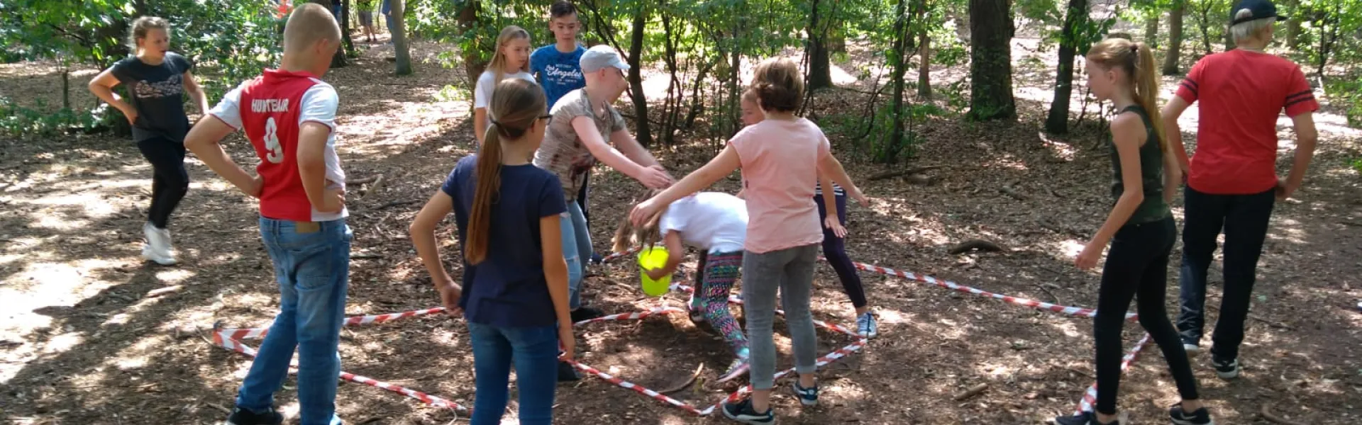 Deelnemers spelen een spel op het zandveld