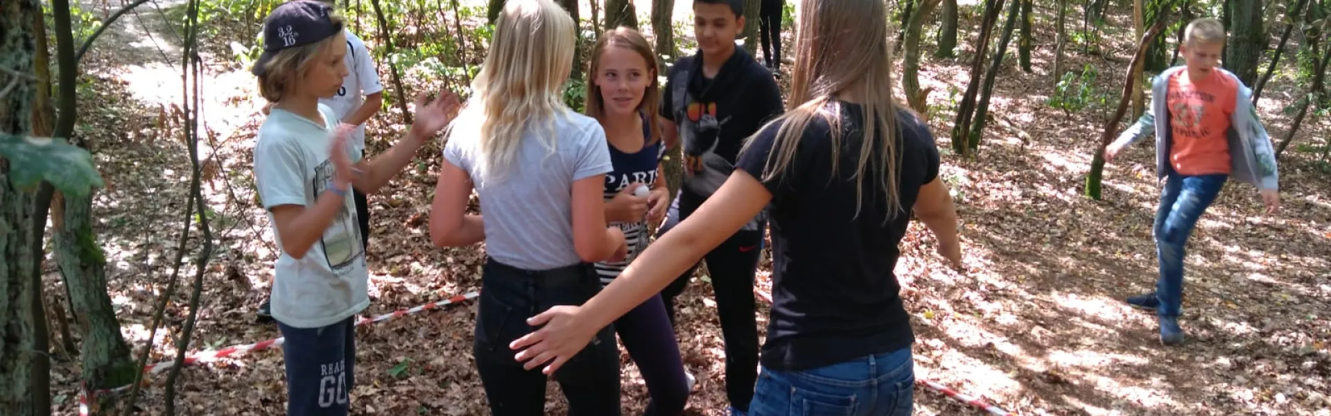 Deelnemers staan in een kring in het bos