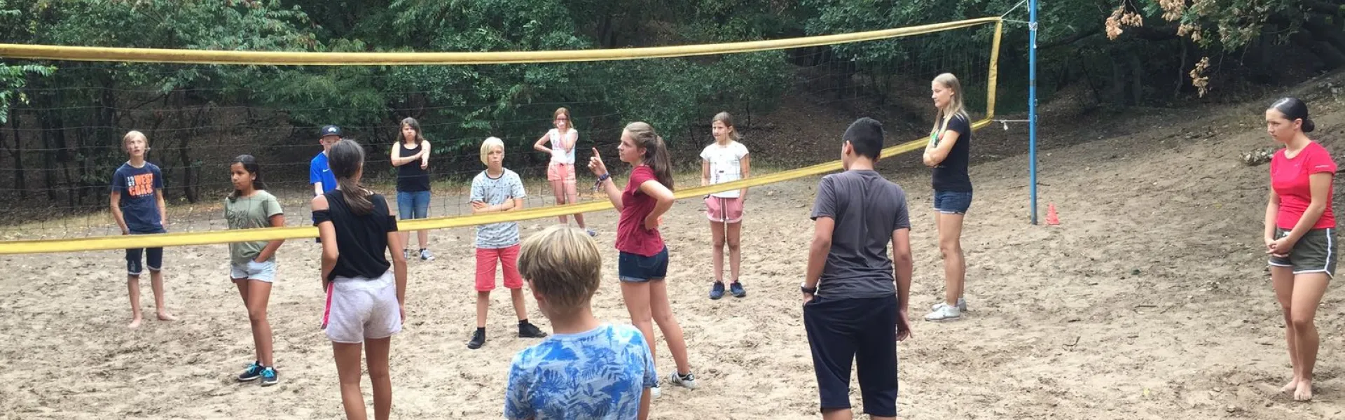 Deelnemers bij het volleybalnet op het zandveld