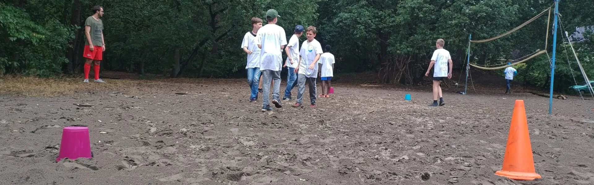 Deelnemers spelen een spel op het zandveld