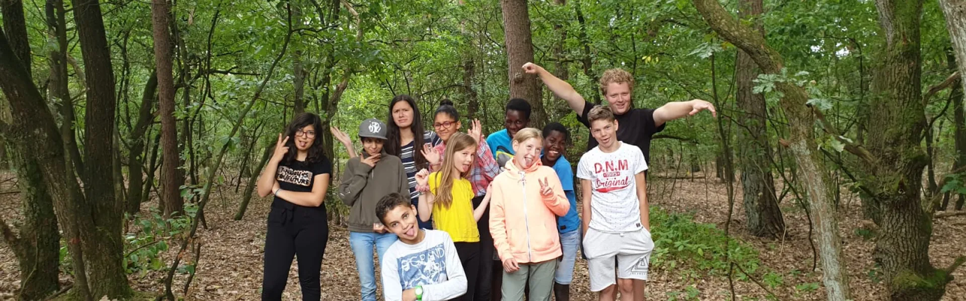 Deelnemers poseren in het bos