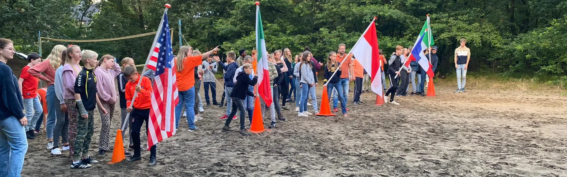 Deelnemers met vlaggen van verschillende landen op het zandveld