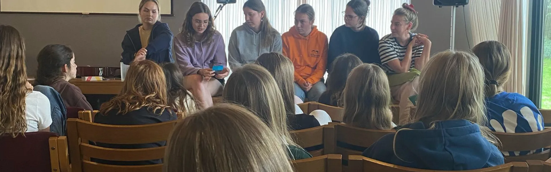 Deelnemers zitten in de zaal tijdens het programma